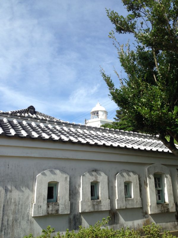 青空を背景にした官舎の漆喰屋根と伊王島灯台のツーショットは、伊王島灯台公園のベストショットです。
